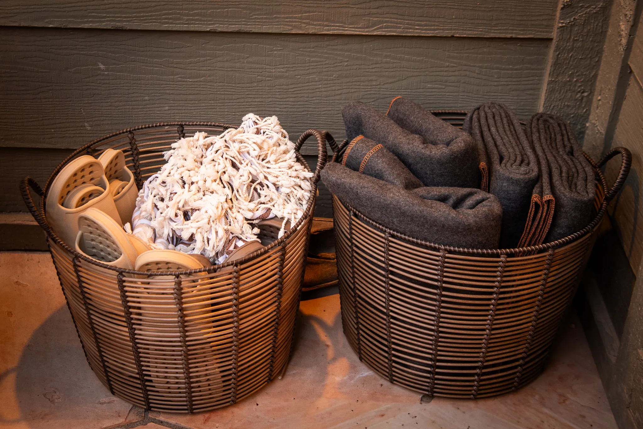 Woven baskets holding spa sandals, fringed towels, and wool blankets for a Sedona wellness retreat.