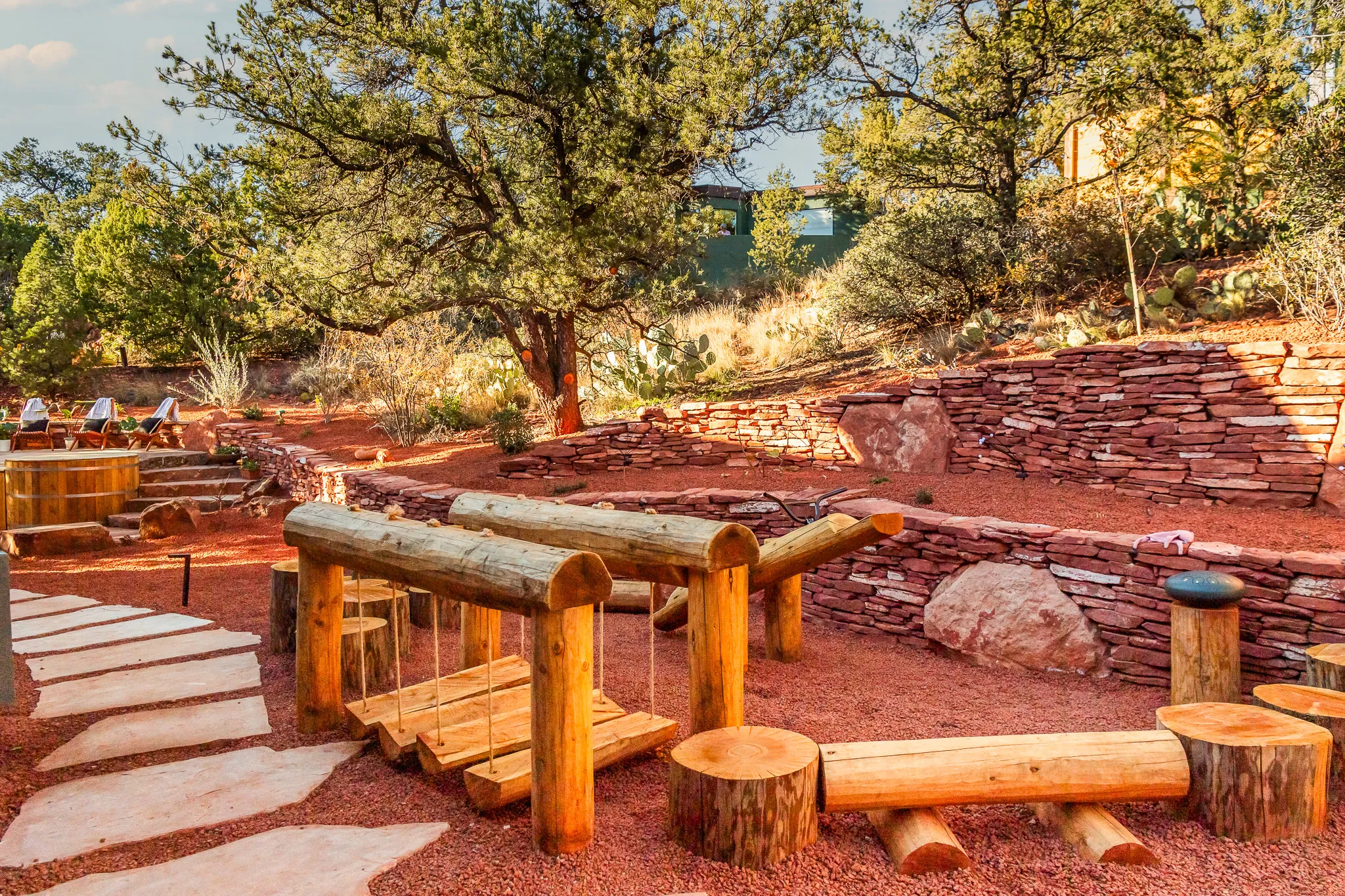 Natural wood log playground and stump steps in a red rock backyard setting in West Sedona.