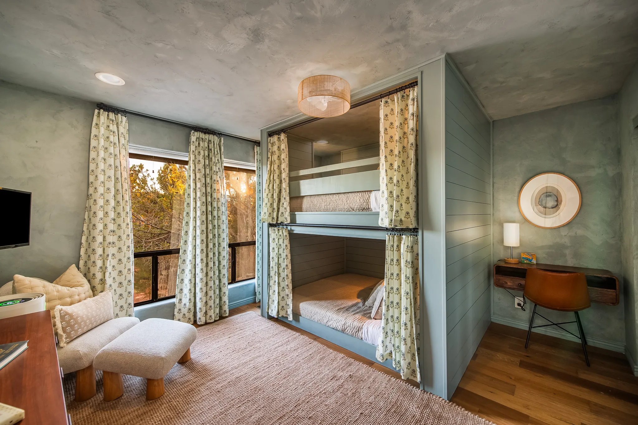 Round designer bedroom with white king bed, organic linens, and desk workspace in a West Sedona retreat.